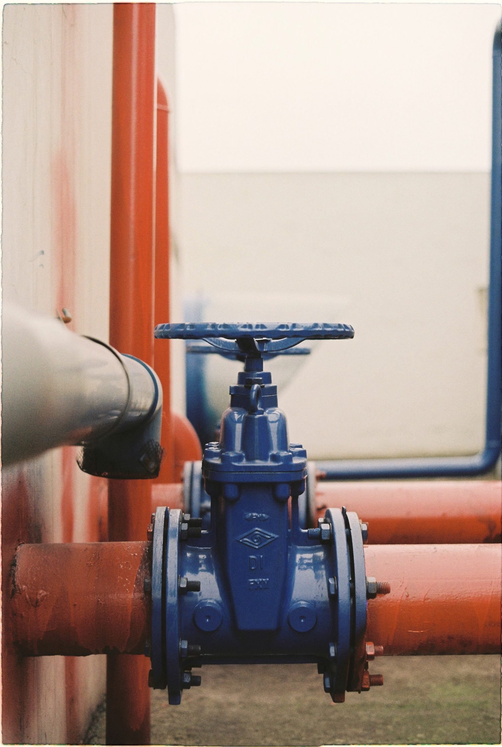 Blue gate valve with a handwheel set into red pipe
