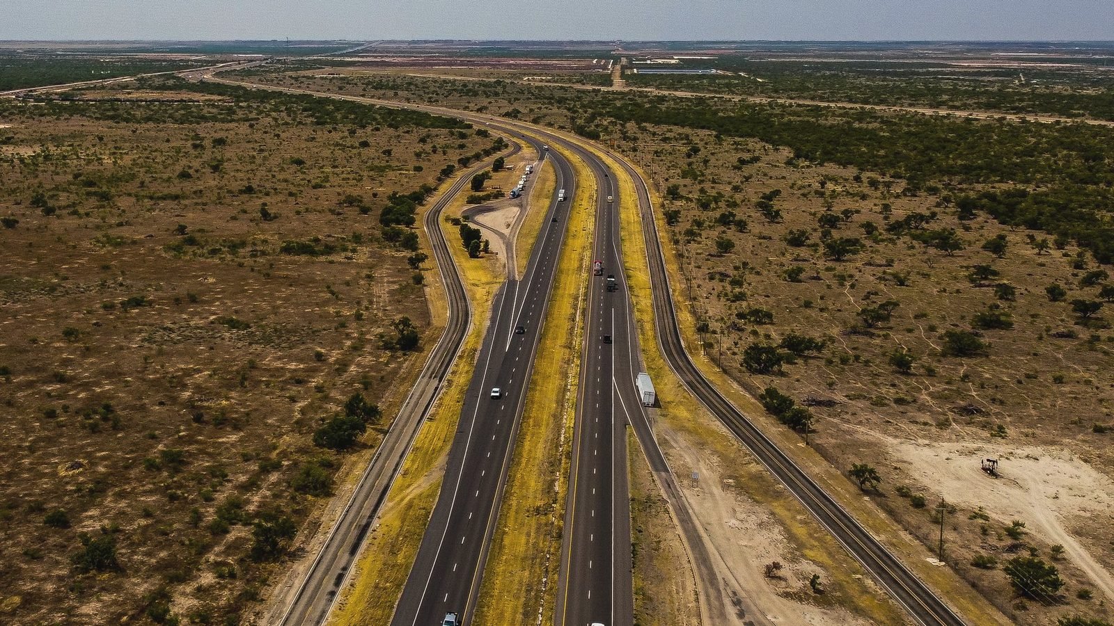 Aerial view of a divided highway running through flat brush country near Midland